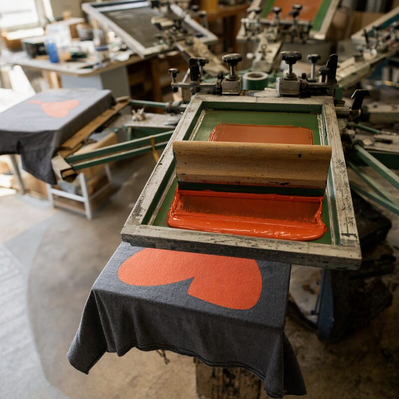A screen printing carousel – a squeegee pushing ink through the mesh